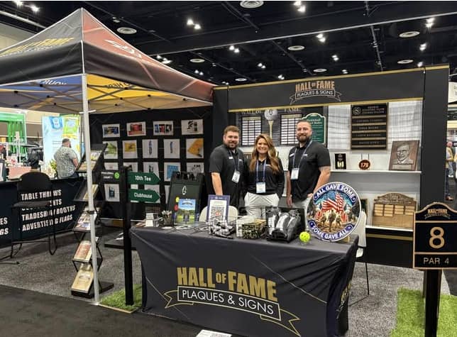 The team at their booth for Hall of Fame Plaques