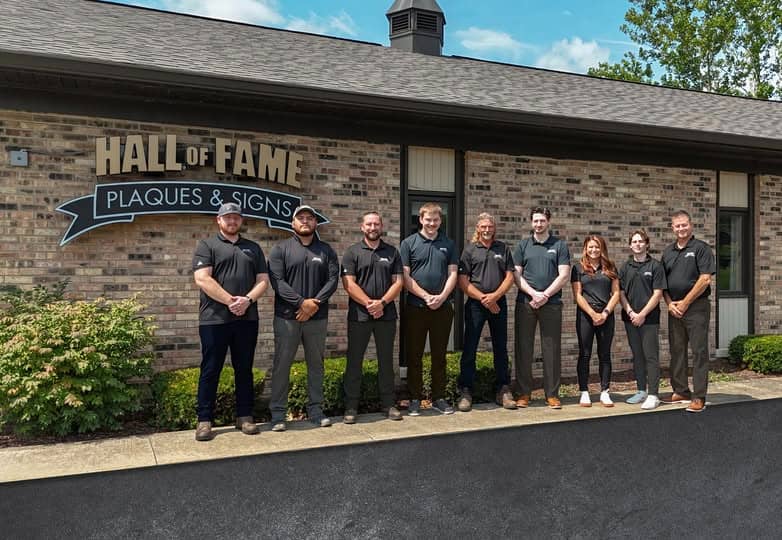 The team in front of Hall of Fame Plaques