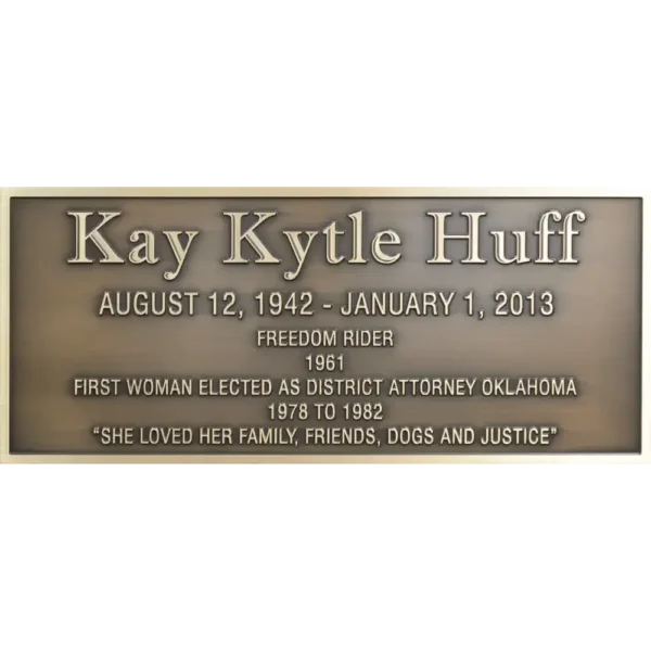 Rectangular bronze historical civic memorial plaque with clean raised lettering dedicating a local hero.