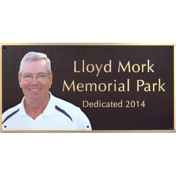 Bronze park memorial dedication plaque featuring a built-in full-color oval ceramic photo portrait.