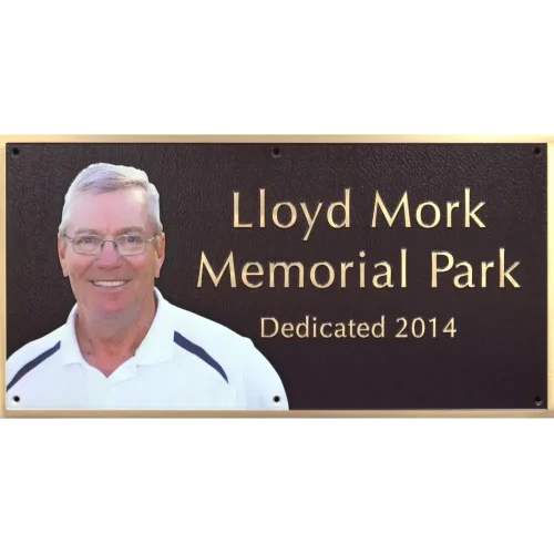 Bronze park memorial dedication plaque featuring a built-in full-color oval ceramic photo portrait.